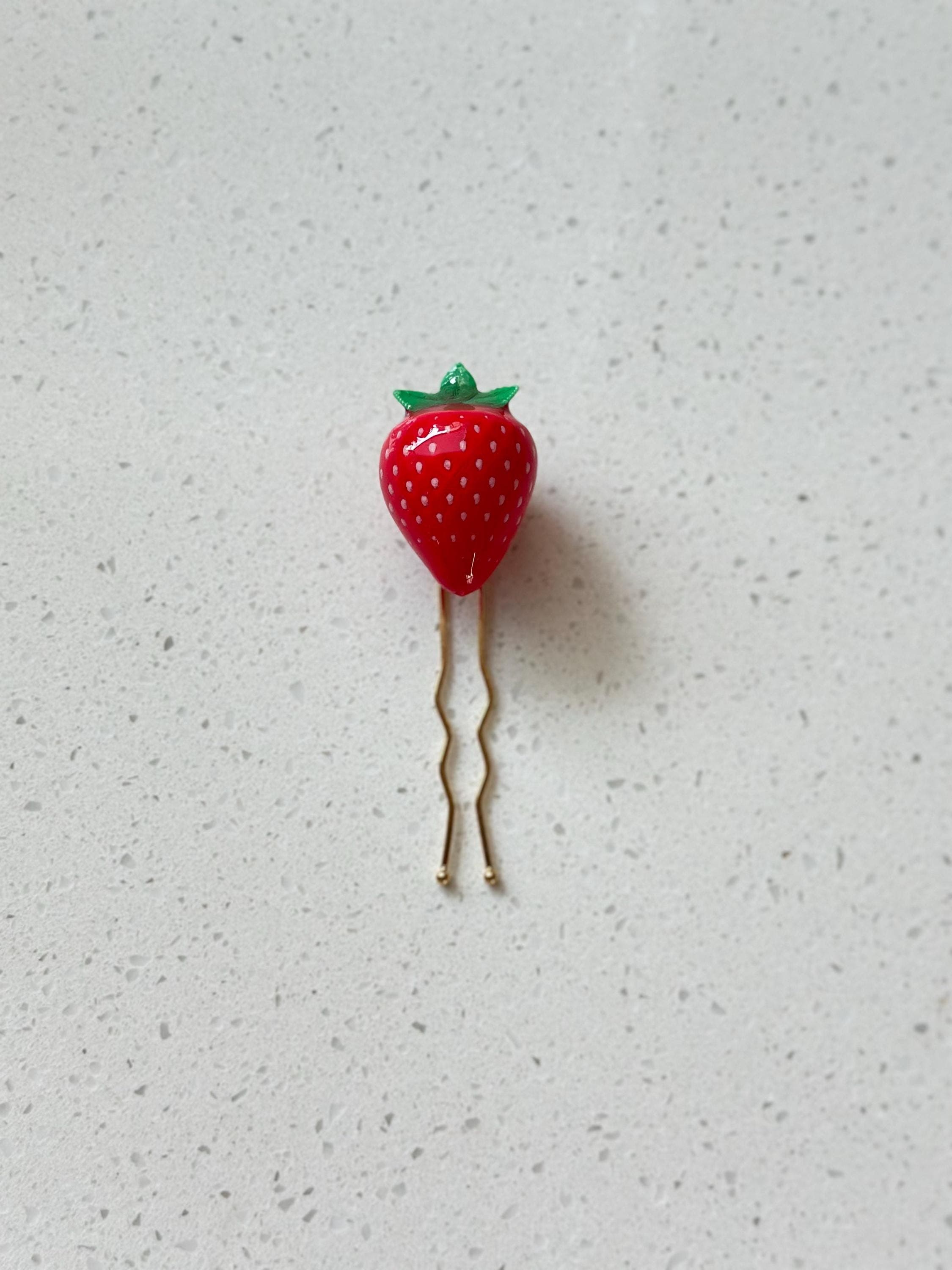 A handcrafted strawberry hair pin